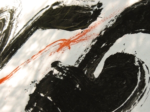 Closeup photograph of red and black calligraphy strokes on white paper using a big brush